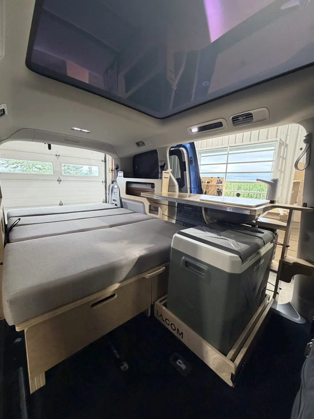 Samhall déplié en lit dans un Volkswagen ID. Buzz, avec la cuisine et la glacière