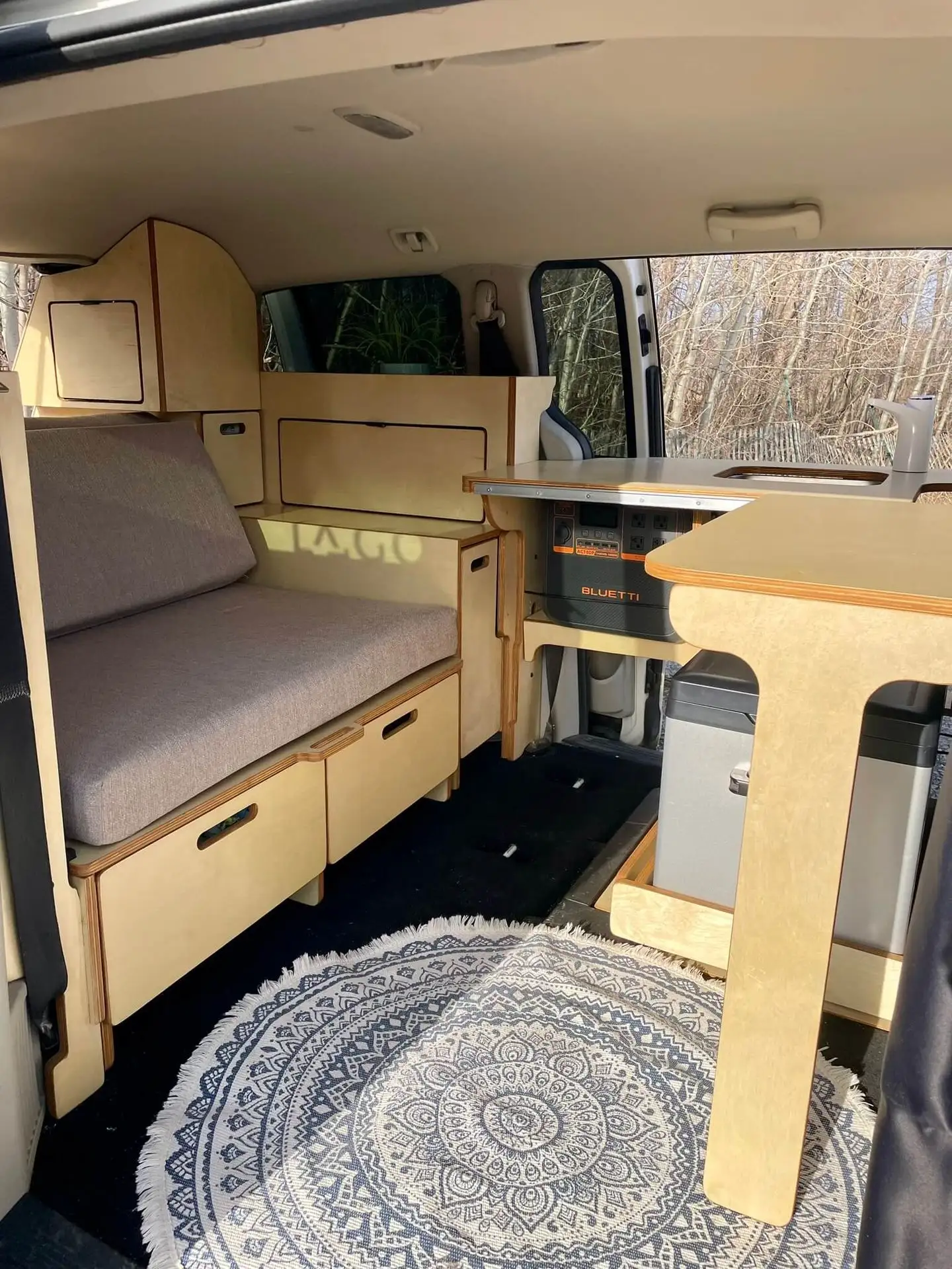 Intérieur d’un minivan avec un kit Lagom, comprenant des tiroirs pratiques et un frigo compact intégré.